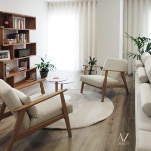 sala de estar com estante para livros, cadeiras, plantas e tapete